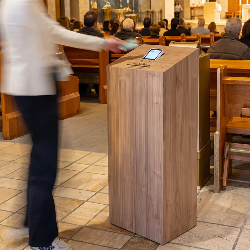 Kiosko de madera dentro de iglesia para recibir donativos digitales con tarjeta.